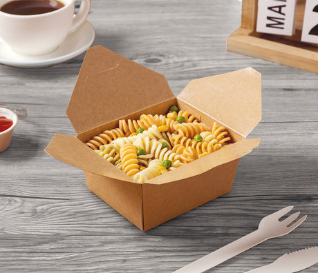 kraft box filled with rotini, paper fork on grey wood surface