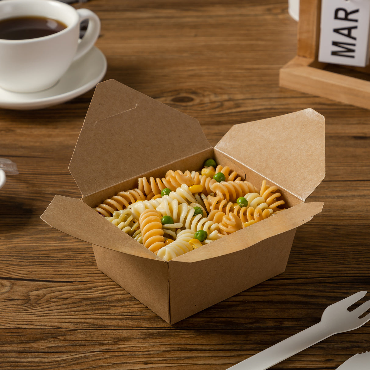 kraft box filled with fusilli and beans on a brown wooden table