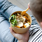 a person is hold a salad bowl of fusilli salad