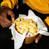 a person is hold a bowl of poutine